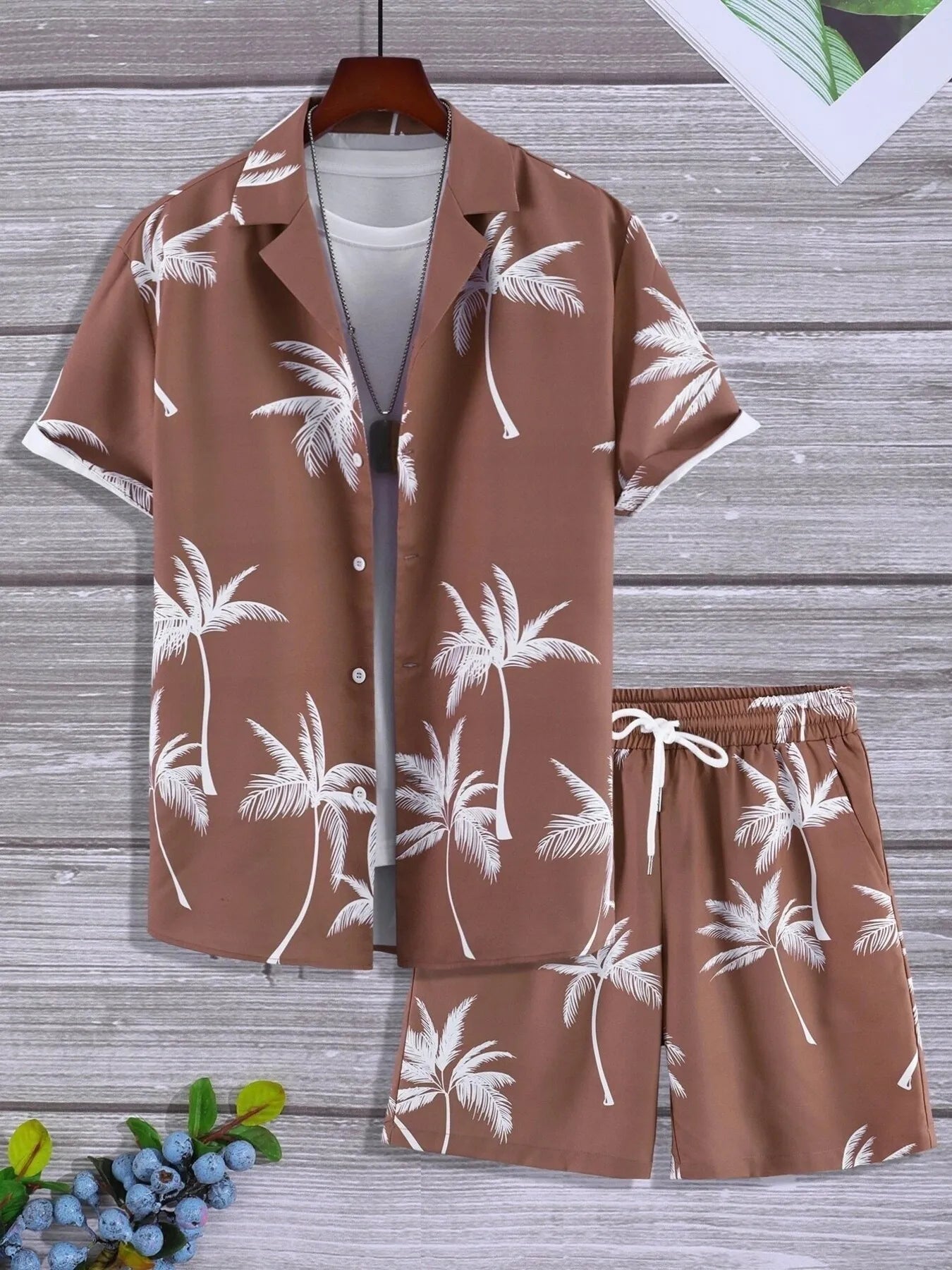 Brown shirt and shorts set with palm tree pattern on a wooden surface.