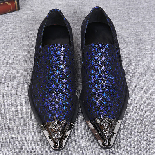 Blue patterned loafers with decorative toes on a gray fabric background