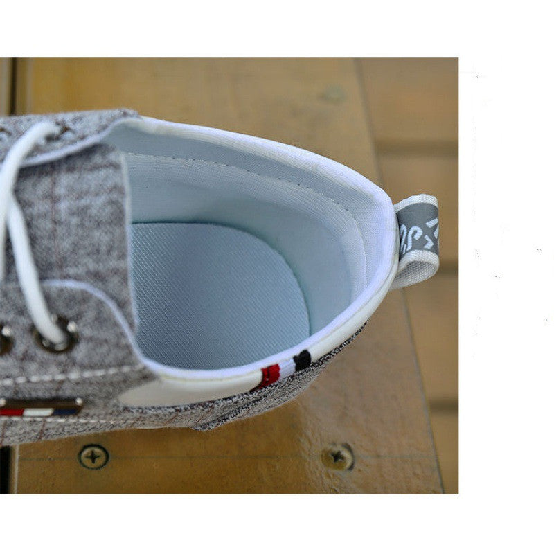 Close-up of a gray shoe with white laces on a wooden surface