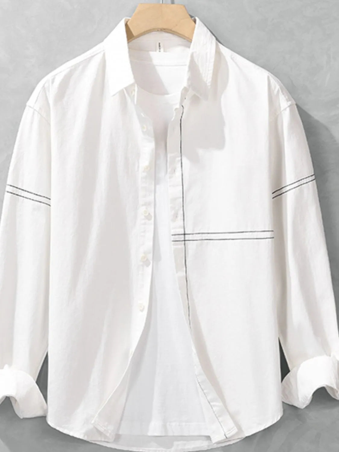 White shirt on a hanger against a gray background