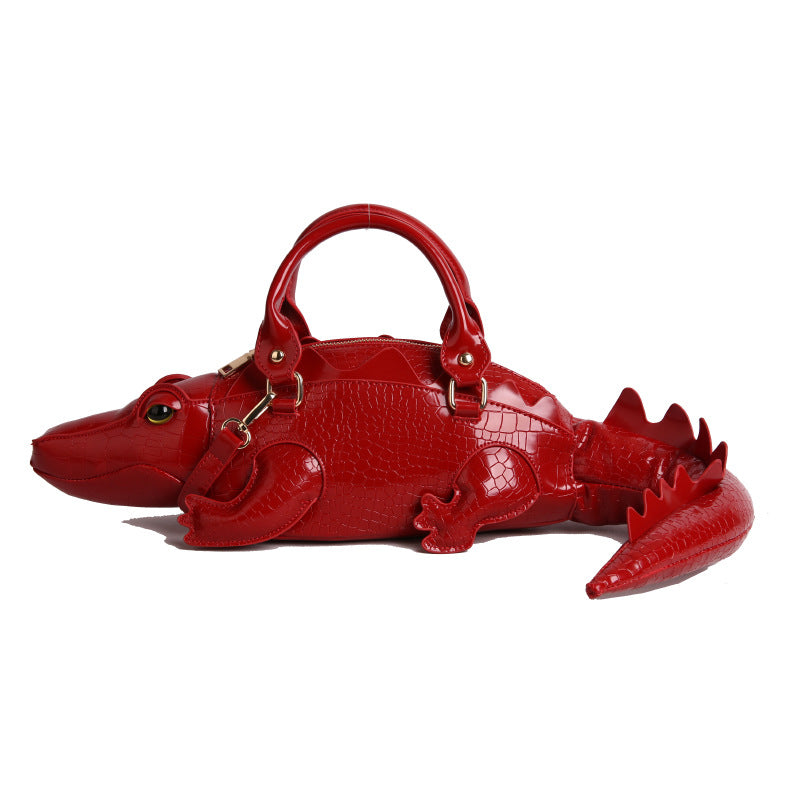 Red alligator-shaped handbag on a white background