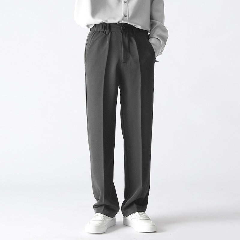 Person wearing gray pants and a white shirt on a white background