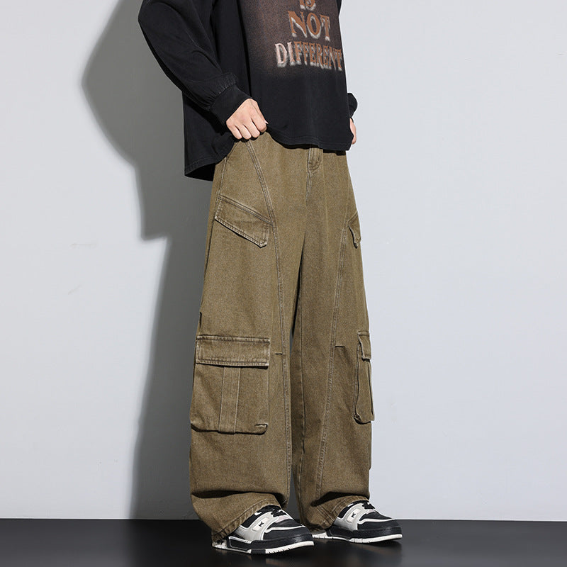 Person wearing olive green cargo pants with a black shirt and sneakers on a gray background