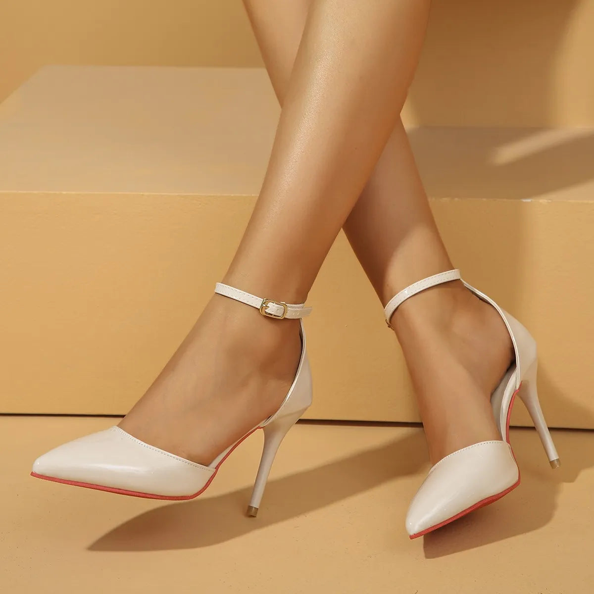 White high-heeled shoes with red soles on a beige background