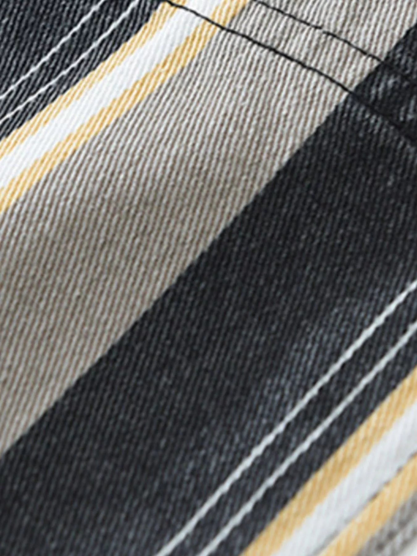 Close-up of a striped fabric with black, white, and beige colors.