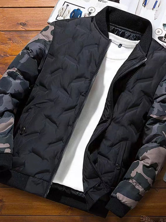 Black puffer jacket with camouflage sleeves on a wooden surface