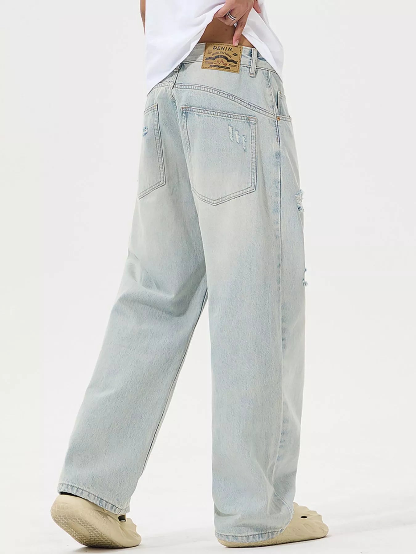 Light blue jeans worn by a person on a white background