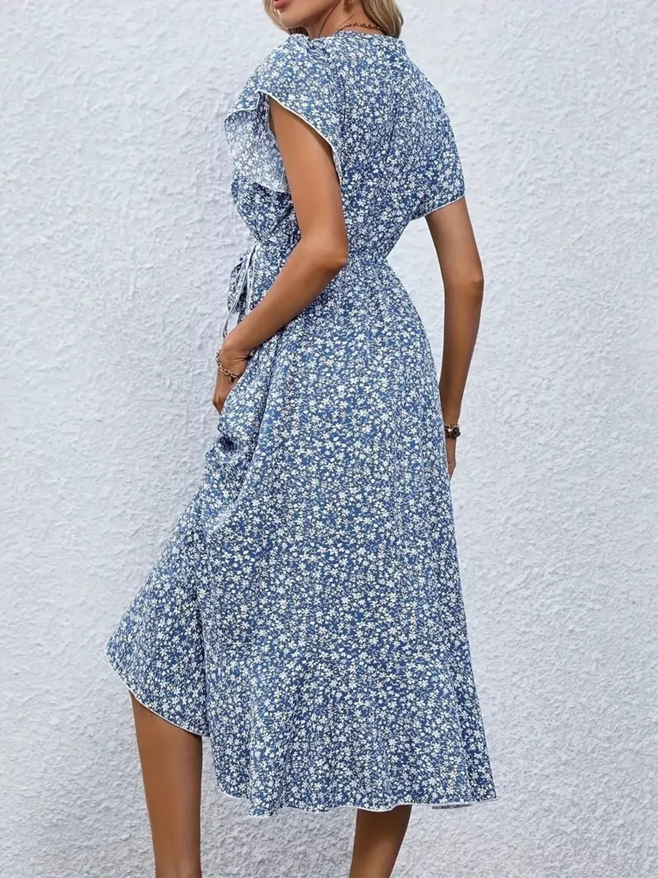 Woman wearing a blue floral dress against a light gray background