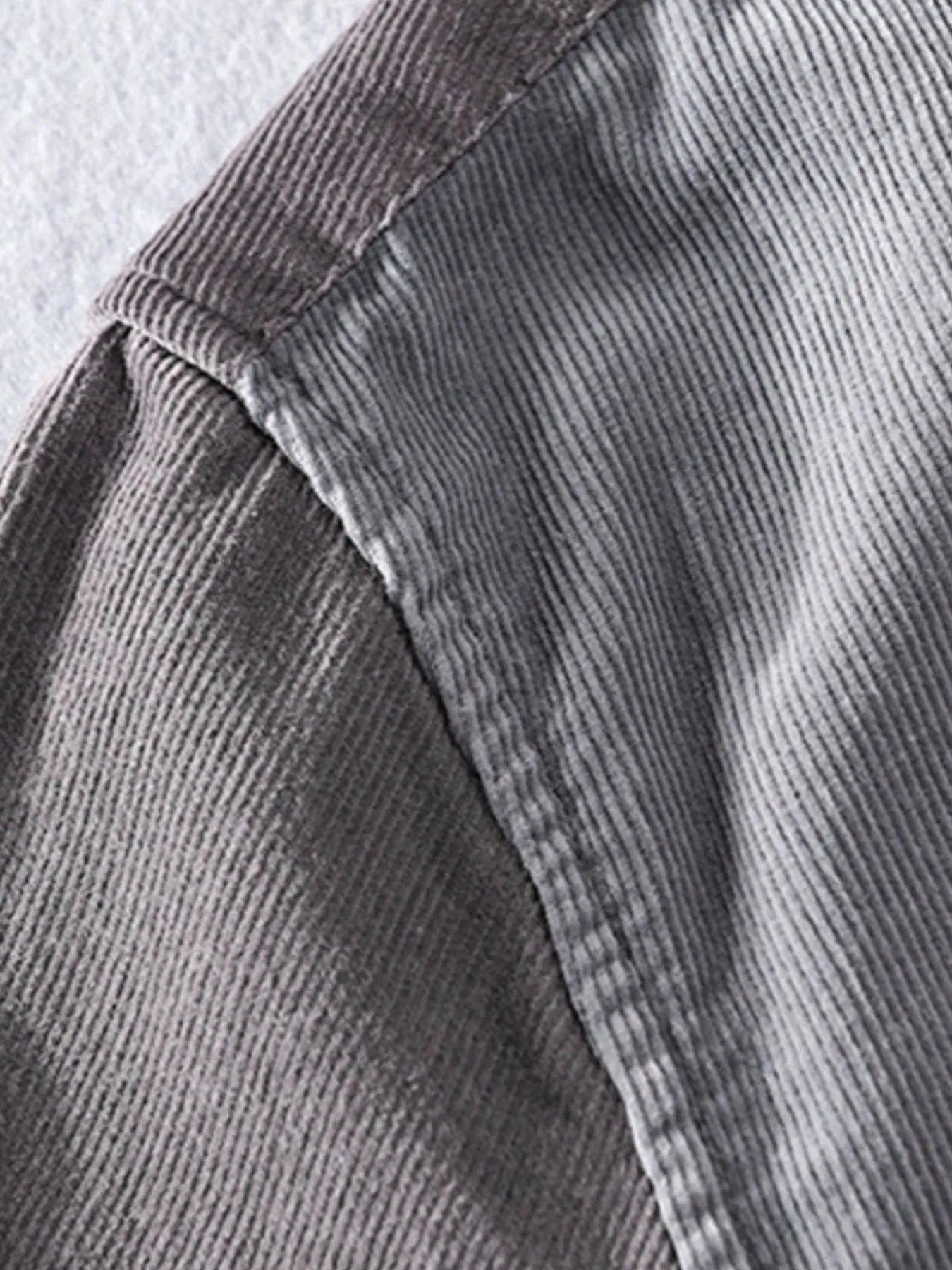 Close-up of gray corduroy fabric with a visible seam