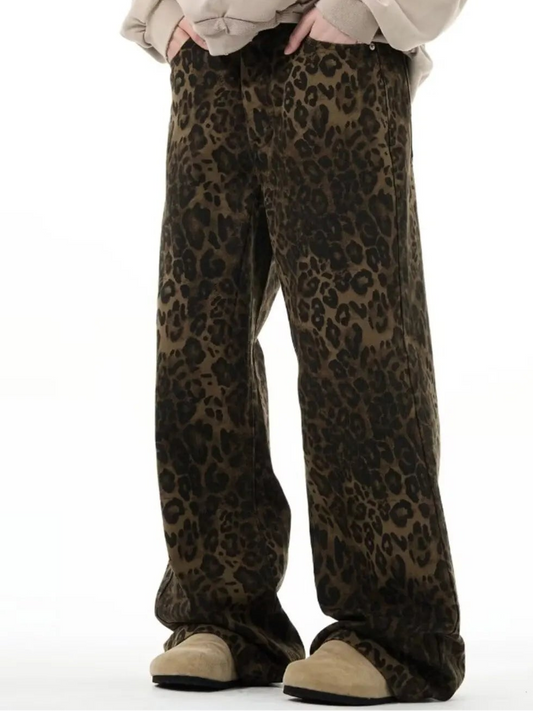 Person wearing a beige oversized sweatshirt and leopard print pants on a white background