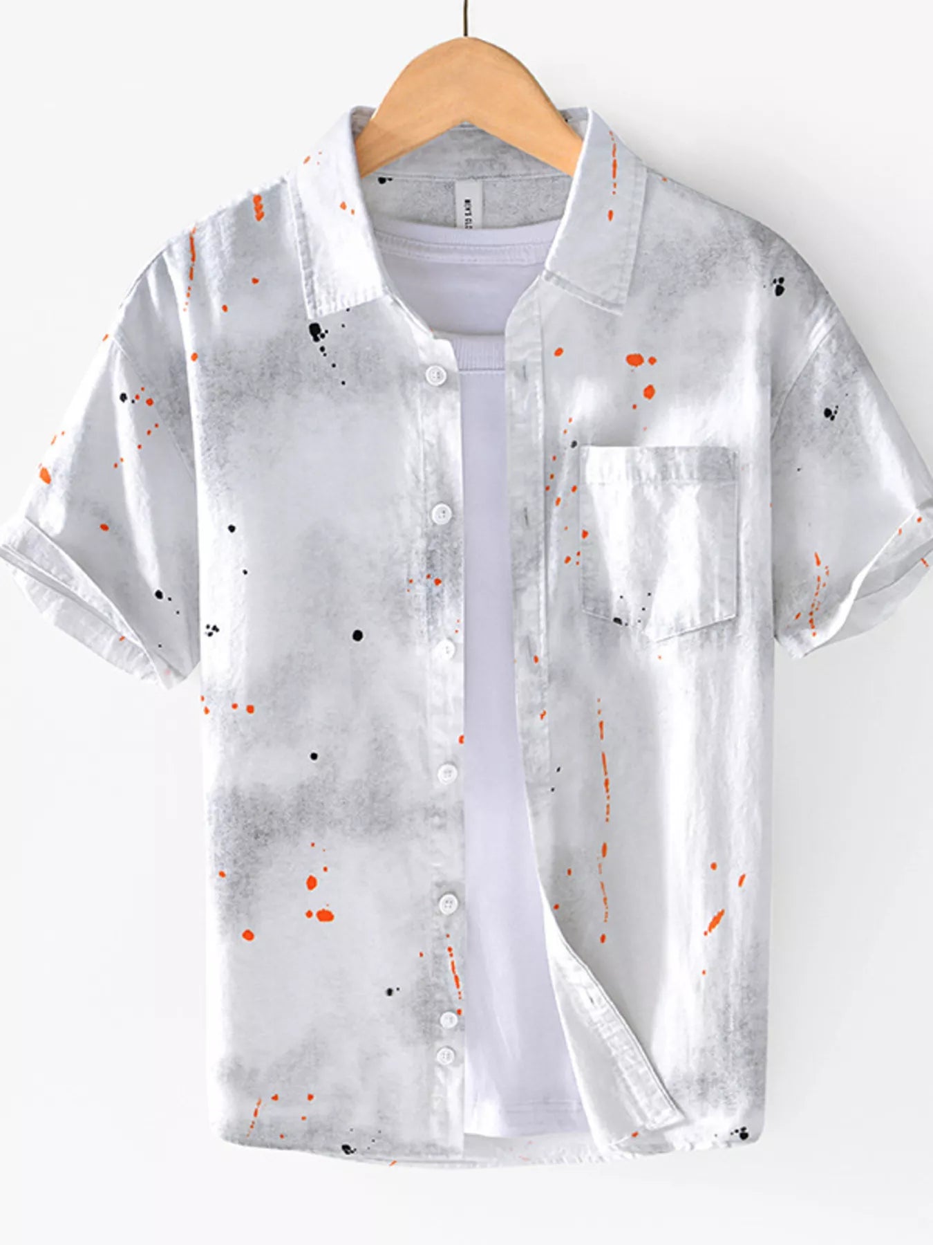 Translucent shirt with colorful speckles on a hanger against a white background