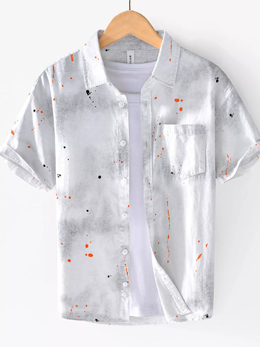 Translucent shirt with colorful speckles on a hanger against a white background