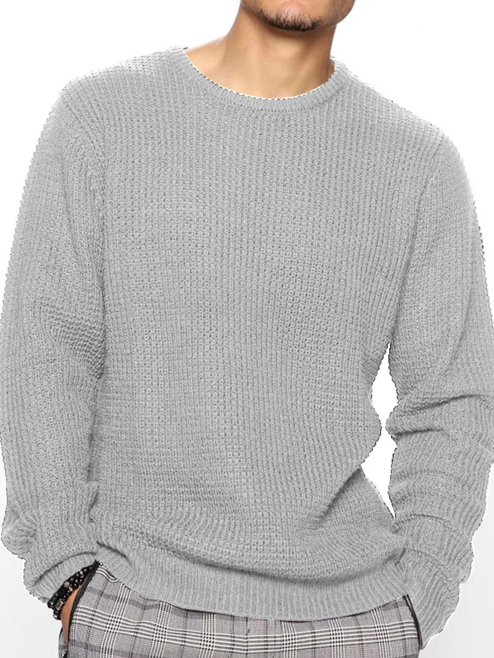 Person wearing a gray knitted sweater on a white background
