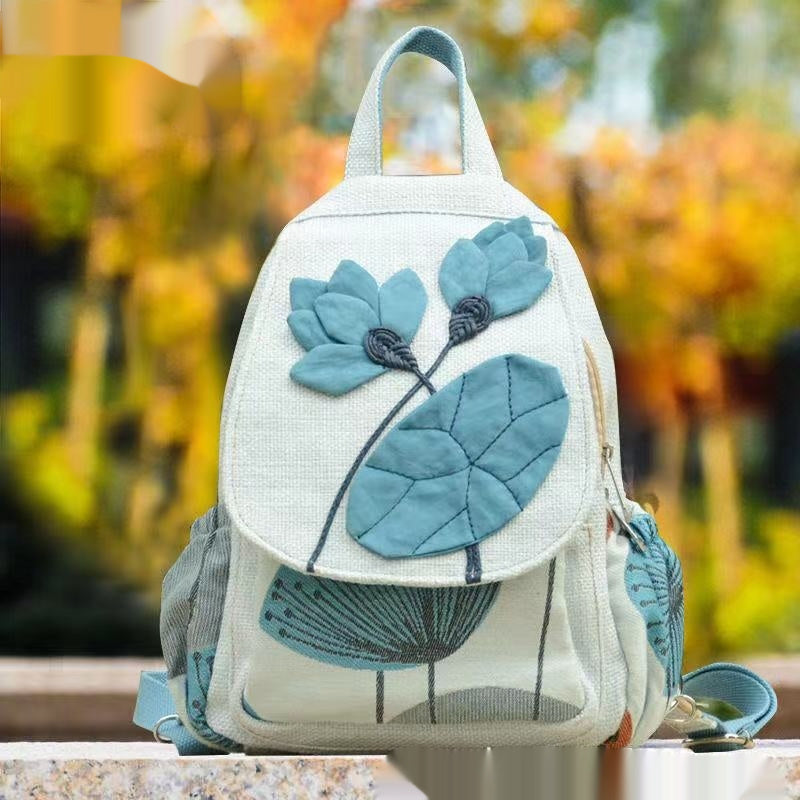 Backpack with blue floral design on a blurred natural background