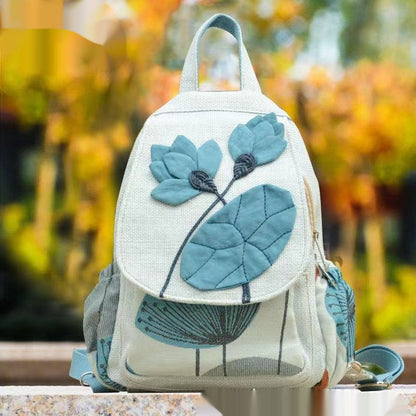 Backpack with blue floral design on a blurred natural background
