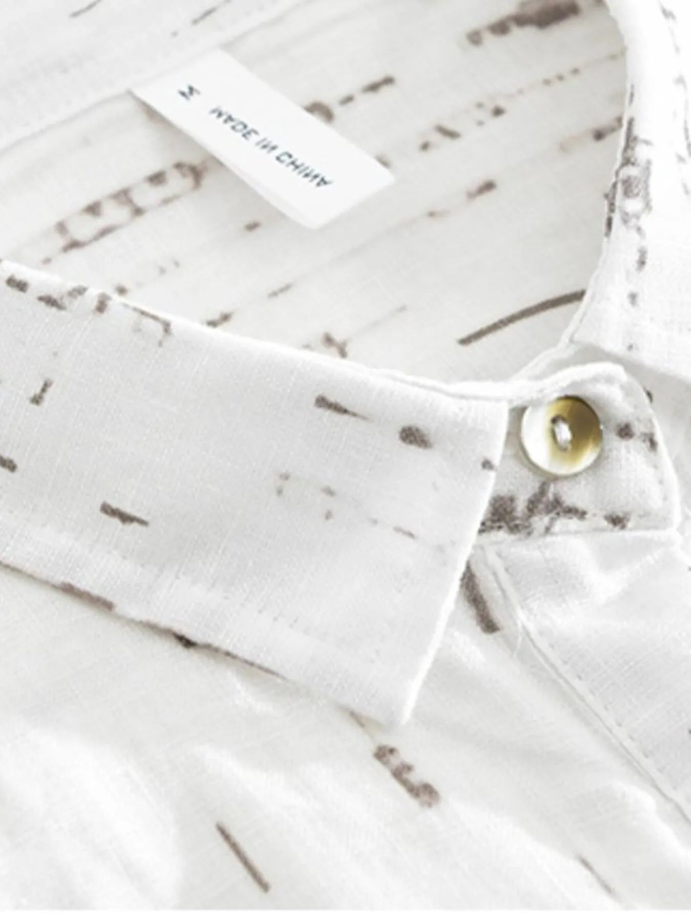 White fabric with a subtle pattern and a button, on a white background.