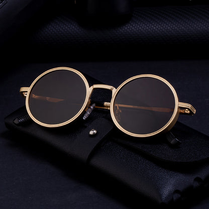 Gold-framed round sunglasses on a dark textured surface