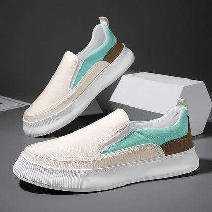 White and turquoise slip-on shoes with brown accents on a dark background