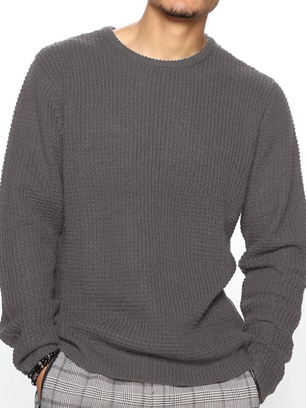 Person wearing a gray sweater on a white background