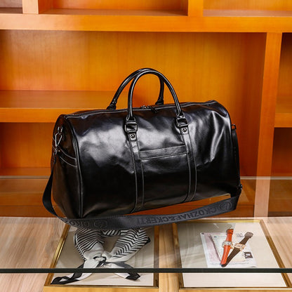 Black leather duffel bag on a glass table with a wooden shelf background