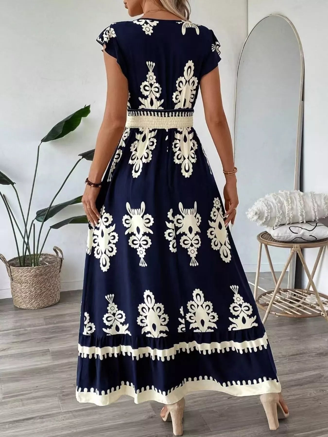Navy blue dress with white patterns worn by a person indoors.
