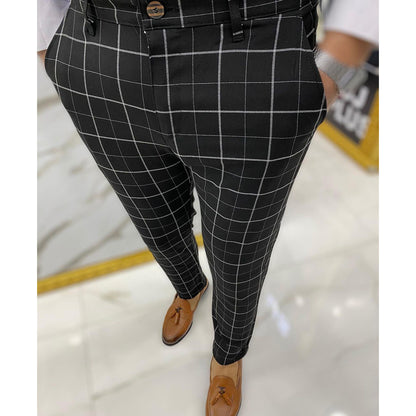 Black checkered pants worn by a person on a light floor.