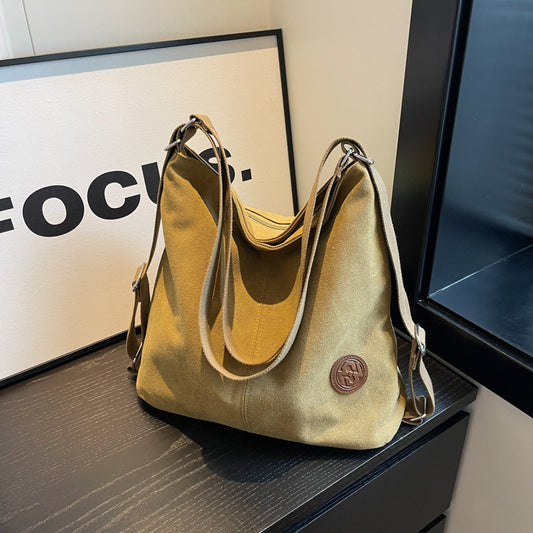Beige handbag on a dark surface with a blurred background