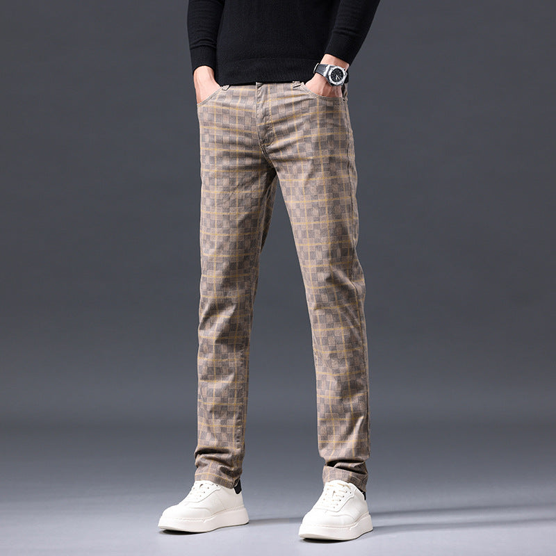 Person wearing plaid pants and white sneakers on a gray background