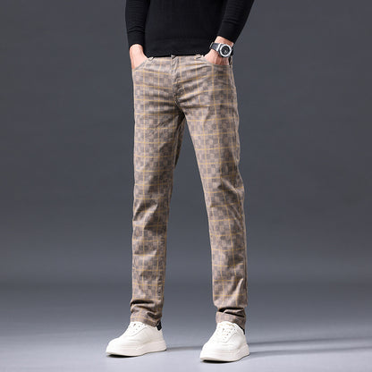 Person wearing plaid pants and white sneakers on a gray background