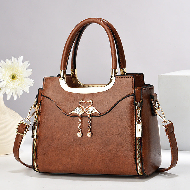 Handbag with gold accents with a single flower and white background.