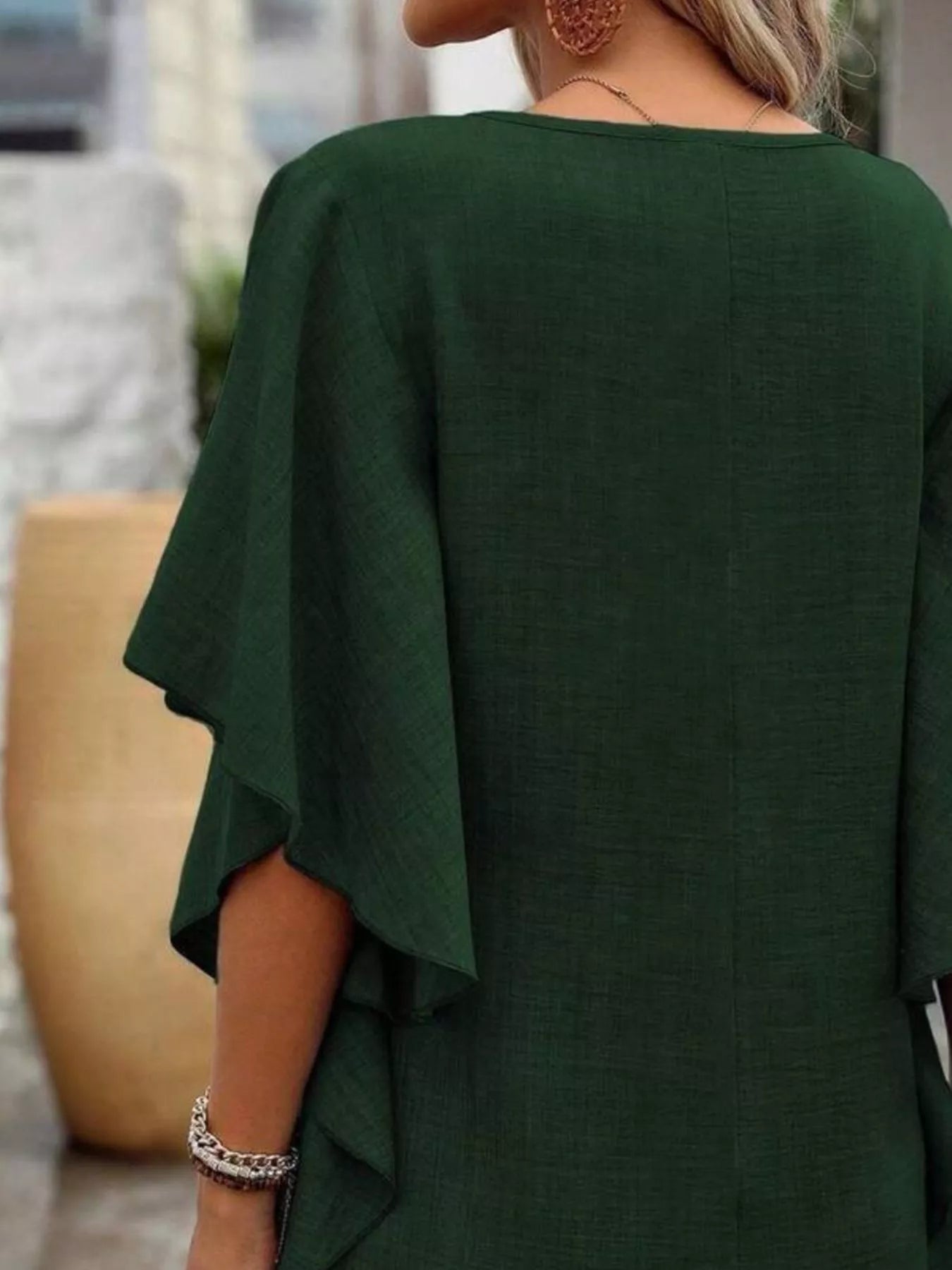 Green dress worn by a person with a blurred background