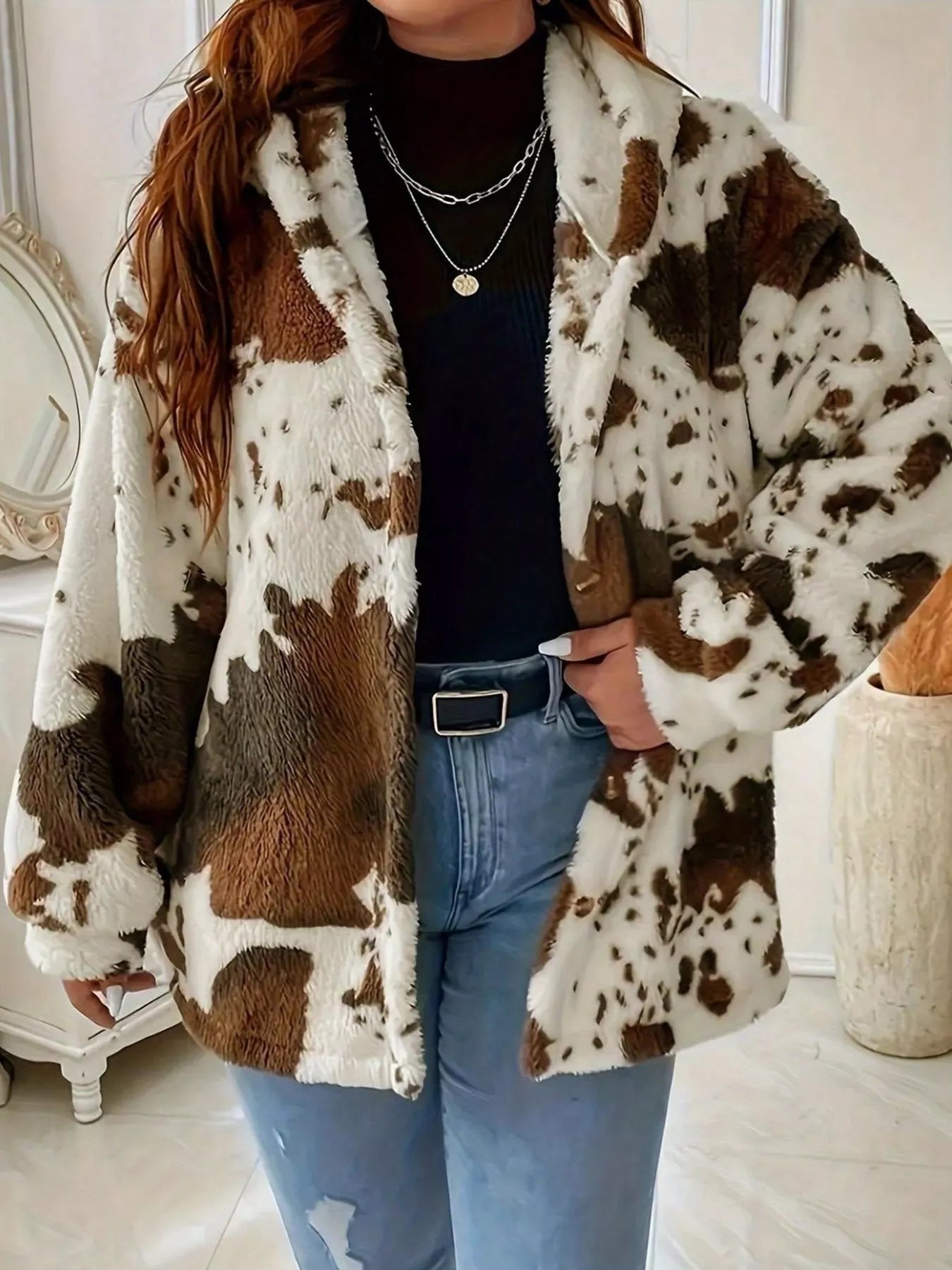 Person wearing a cow print coat in an indoor setting
