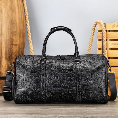 Black textured duffel bag on a wooden surface with a wooden chair in the background