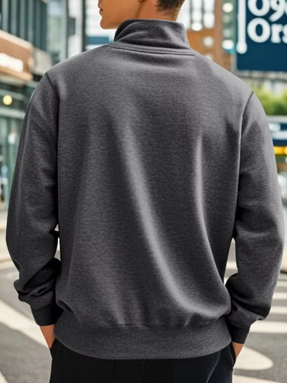 Person wearing a gray jacket with a blurred urban background