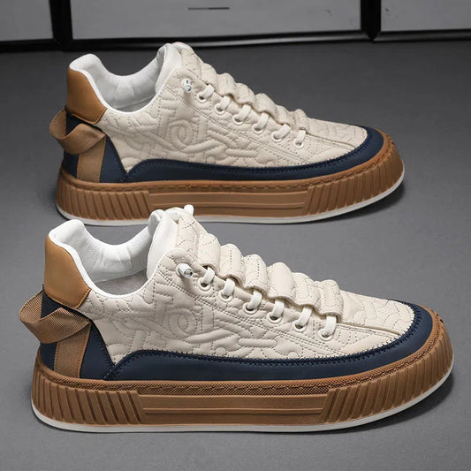 Pair of white sneakers with brown and blue accents on a gray background