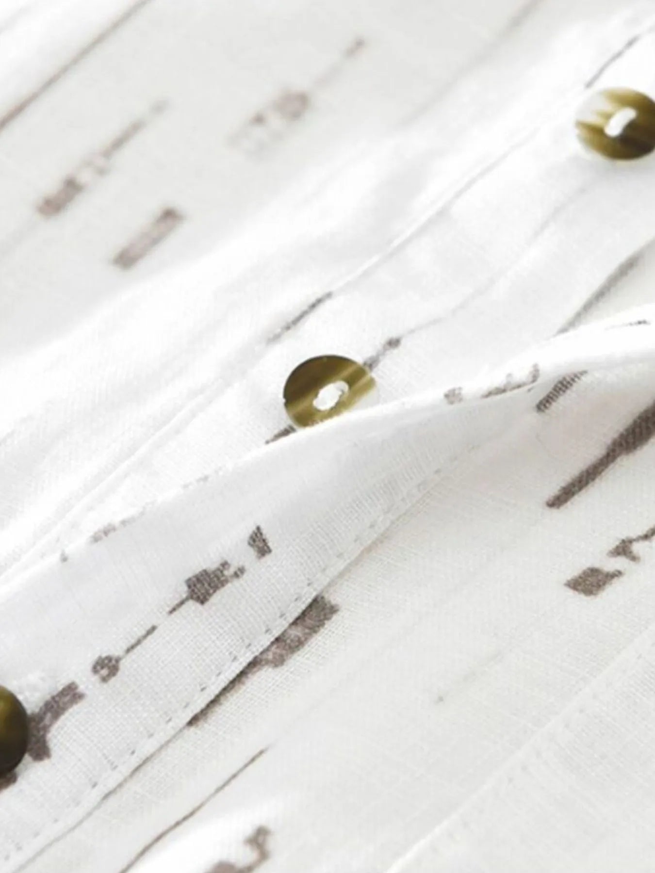 Close-up of a white wooden surface with decorative elements and small round objects.