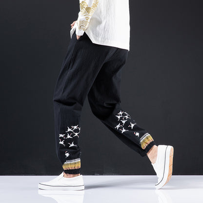 Black harem pants with star patterns and white platform shoes on a dark background