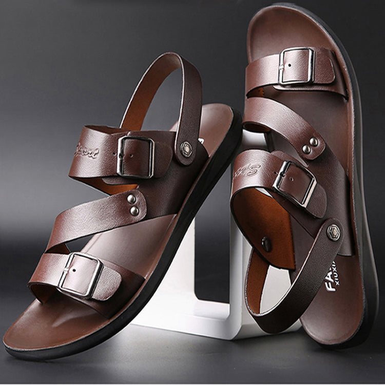 Pair of brown sandals with buckles on a dark background