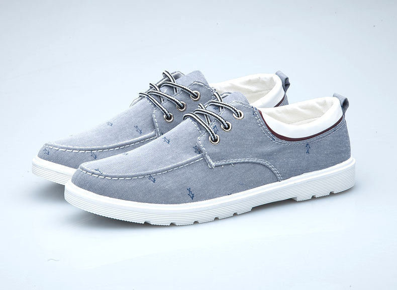 Pair of gray casual shoes with white soles on a light gray background