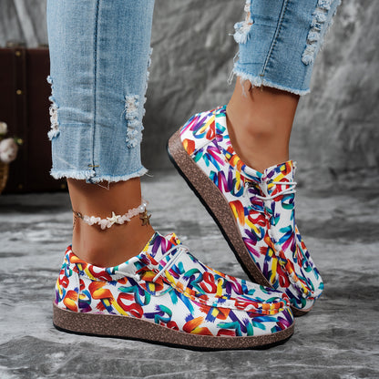 Colorful slip-on shoes with text pattern worn with ripped jeans on a gray surface.
