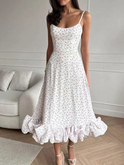 Woman wearing a white floral dress in a room with a gray sofa.