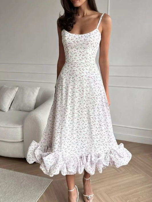 Woman wearing a white floral dress in a room with a gray sofa.