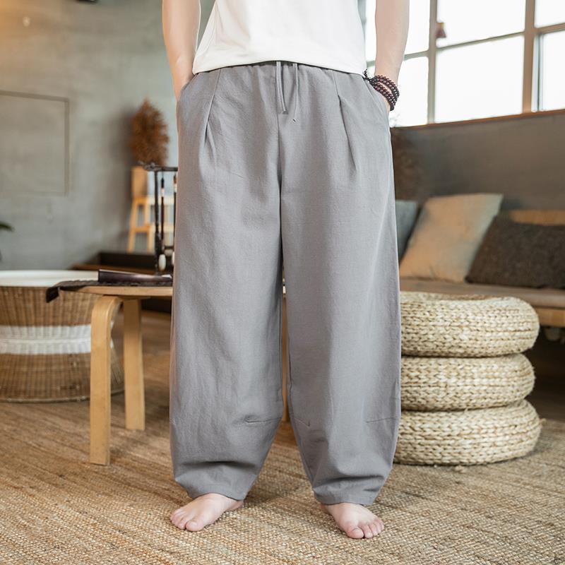 Person wearing gray wide-leg pants in a living room setting