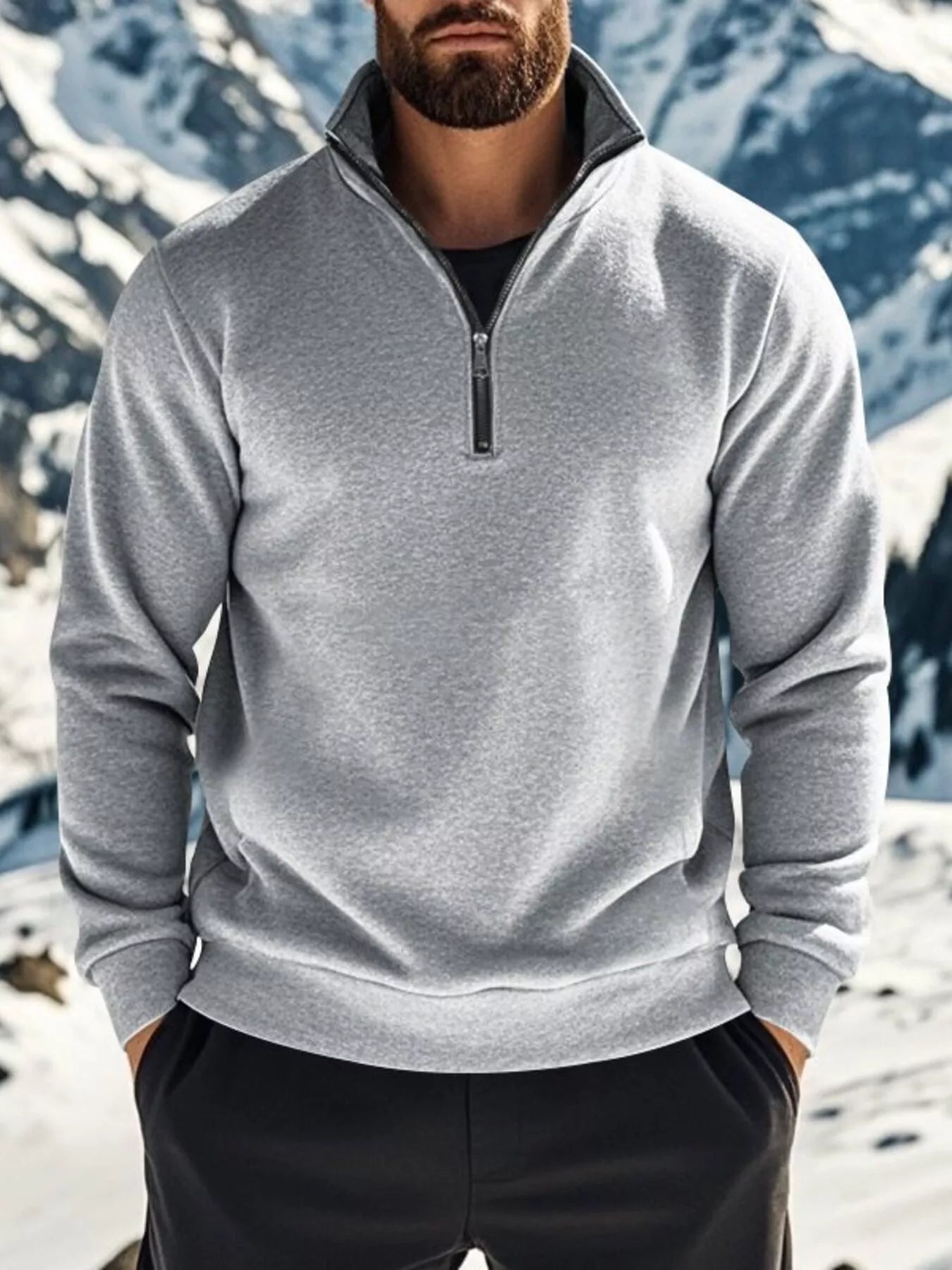 Person wearing a gray pullover with a mountainous background