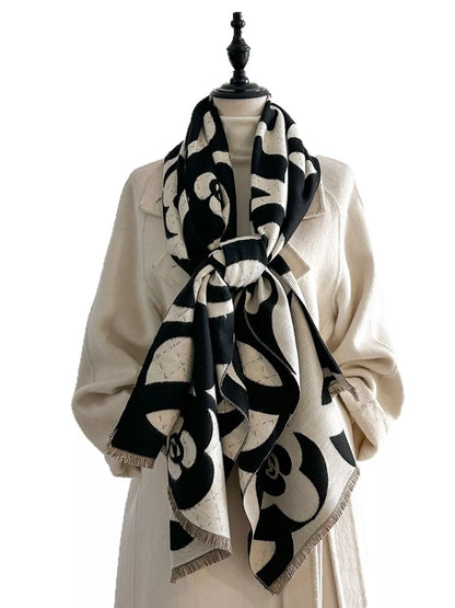 Mannequin wearing a black and white patterned scarf with a plain background
