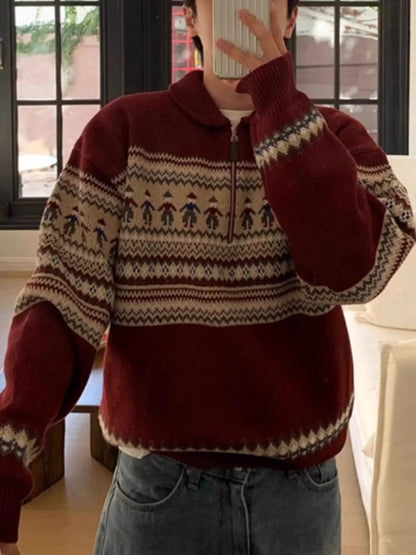 Person wearing a red sweater with a pattern, standing indoors.