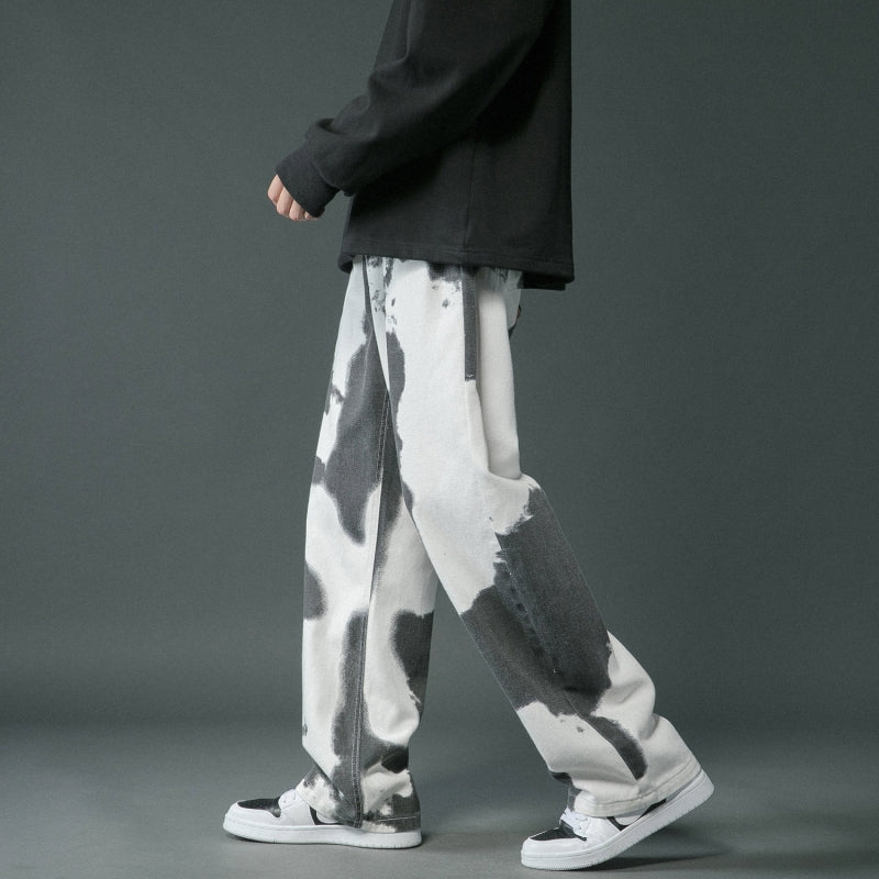 Person wearing black and white patterned pants on a gray background