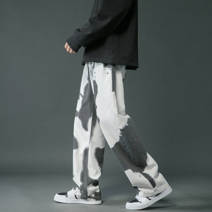 Person wearing black and white patterned pants on a gray background