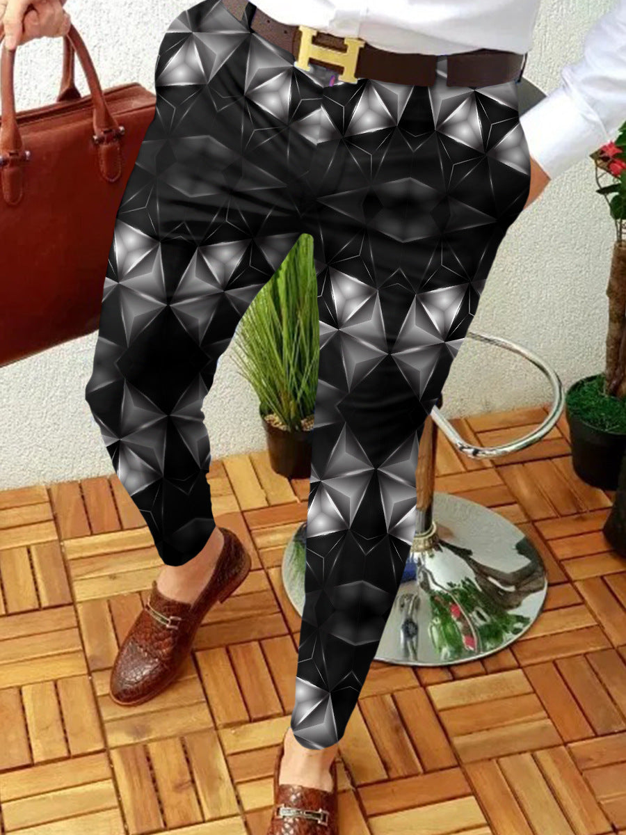 Person wearing black geometric-patterned pants on a wooden floor.