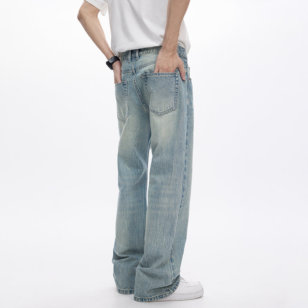 Person wearing light blue jeans and a white shirt on a white background